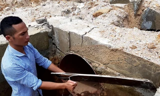 Miếng ván được đóng lại để che điểm nối giữa ống sắt và máng bê tông bị nứt toác