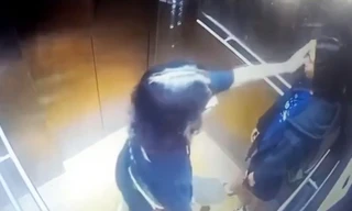 Hai cô gái cầm ván trượt patin đi từ ngoài chung cư vào thang máy.