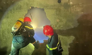 Lính cứu hỏa đục tường vào nhà tìm nạn nhân.