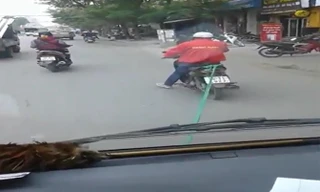 Xe máy kéo ôtô hết xăng đi trên phố Hà Nội