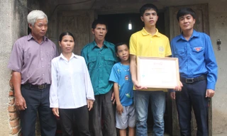 Anh Lê Văn Châu - phó bí thư Tỉnh đoàn Thanh Hóa (bìa phải) tặng bằng khen cho em Lê Hữu Hiếu sáng 9/7. Ảnh: Hoàng Lam.