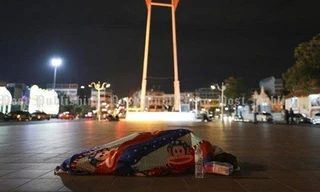 Một người vô gia cư đắp chăn trên đườg phố Bangkok trong cái lạnh 16 độ C - Ảnh: Patipat Janthong/ Bangkok Post 