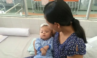 Bé Minh Phát trong vòng tay mẹ ngày xuất viện. 