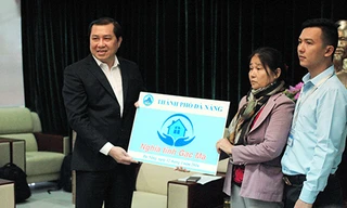 Chủ tịch UBND TP Đà Nẵng Huỳnh Đức Thơ trao tặng nhà chung cư cho vợ và con trai thuyền trưởng Vũ Phi Trừ. Ảnh: Nguyễn Đông.