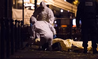 Giới chức làm việc bên thi thể nạn nhân vụ khủng bố Paris. Ảnh: AP