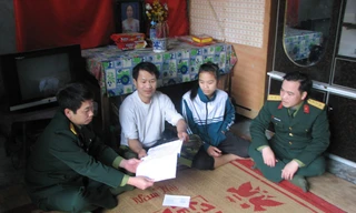 Cán bộ Phòng Chính trị thăm động viên HS nghèo vượt khó tại xóm Mát, xã Dân Chủ, Hòa Bình Ảnh: L.M.T