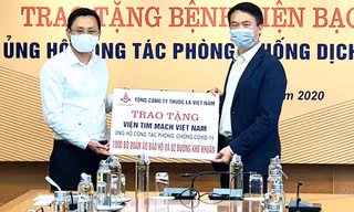 Ông Hồ Lê Nghĩa (bên trái)trao tặng tiền ủng hộ bệnh viện chống covid 19