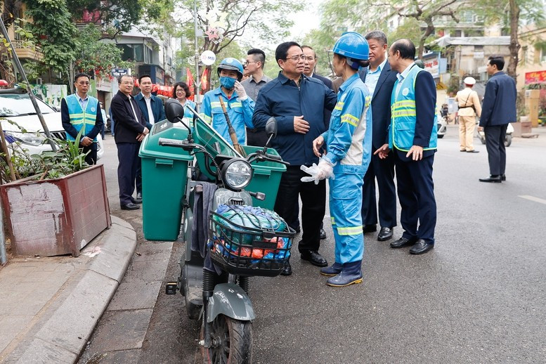 Thủ tướng thăm và động viên công nhân môi trường đô thị đang thực hiện nhiệm vụ tại Phố Nguyễn Thái Học. Ảnh: VGP/Nhật Bắc.