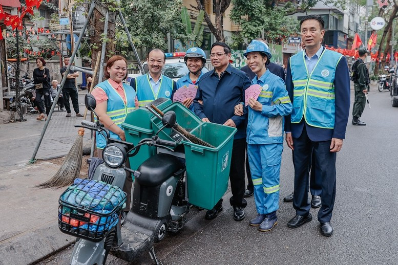 Thủ tướng thăm và động viên công nhân môi trường đô thị đang thực hiện nhiệm vụ tại Phố Nguyễn Thái Học. Ảnh: VGP/Nhật Bắc.