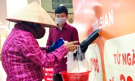 Đội mưa gió, người nghèo đến nhận gạo miễn phí tại 'Máy ATM' quận Bắc Từ Liêm