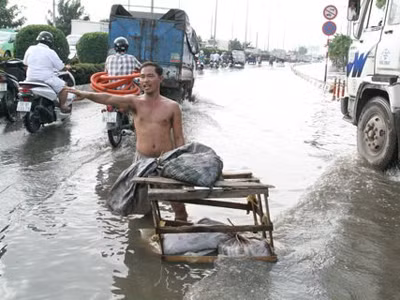Cởi trần đứng giữa phố ngập nước điều tiết giao thông