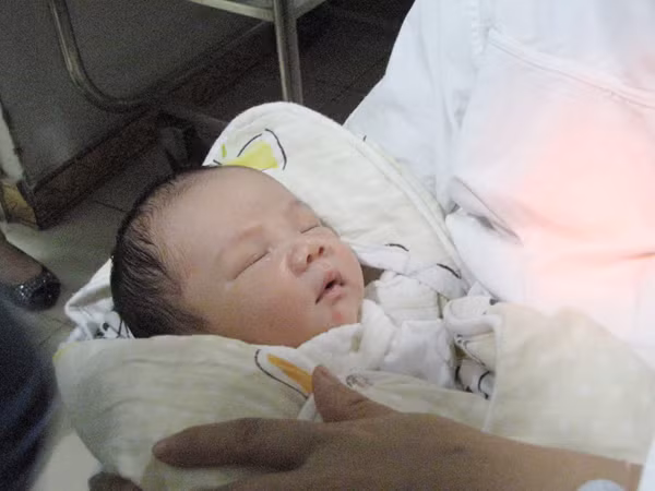 Cháu bé bị bắt cóc đã nằm gọn trong vòng tay người mẹ. Ảnh: Lãng Phong