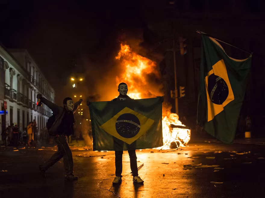 Một người biểu tình cầm cờ Brazil ở Rio de Janeiro hôm 17/6