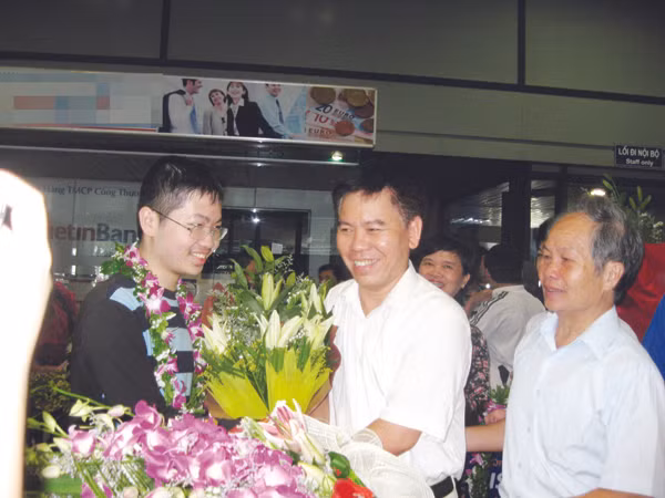 Thày Nguyễn Đức Hoàng chúc mừng Đậu Hải Đăng (trái) tại sân bay Nội Bài. Người ngoài cùng bên phải là bố của Đăng Ảnh: Quý Hiên