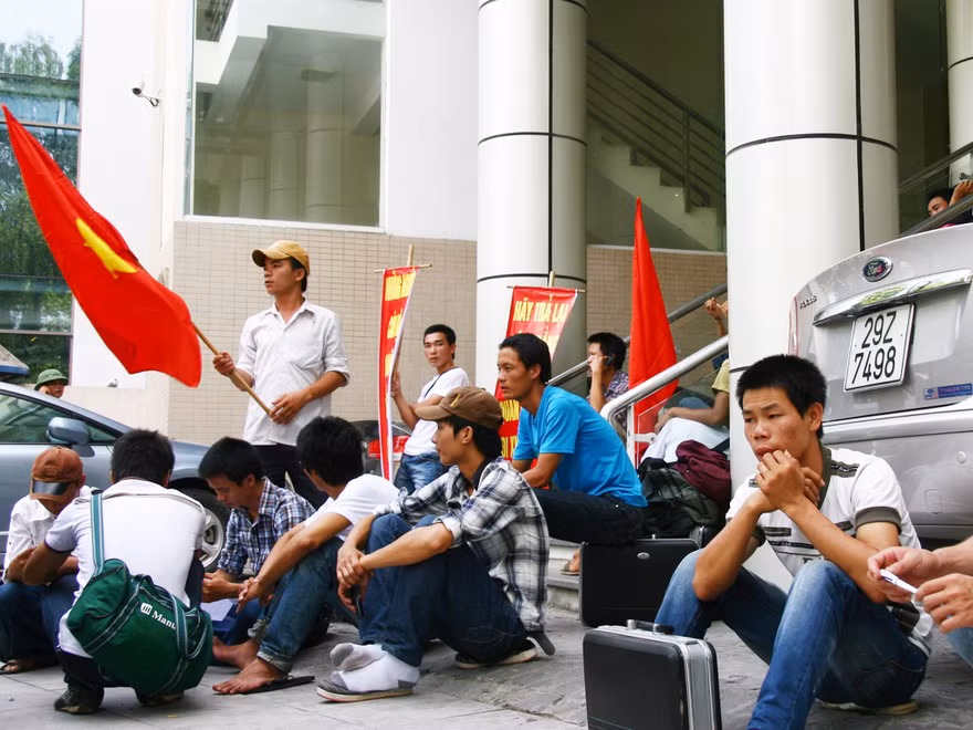 Lao động đứng, ngồi trước trụ sở Cục Quản lý Lao động Ngoài nước (Ảnh chụp ngày 24-6)