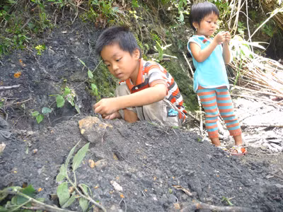 Trẻ em thôn 3 Tiên An chơi đùa bên vùng đất đen. Ảnh: N.T