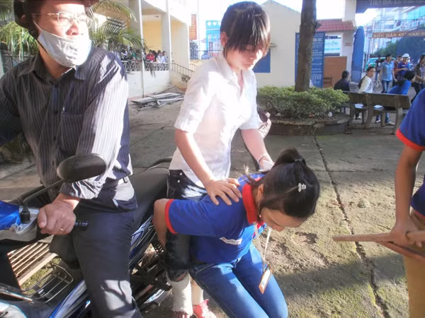 Hồng được sinh viên tình nguyện cõng vào phòng thi