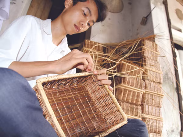 Lê Đức Duẩn, tân thủ khoa ĐH Dược tranh thủ giúp mẹ đan đồ mây tre Ảnh: Trường Phong