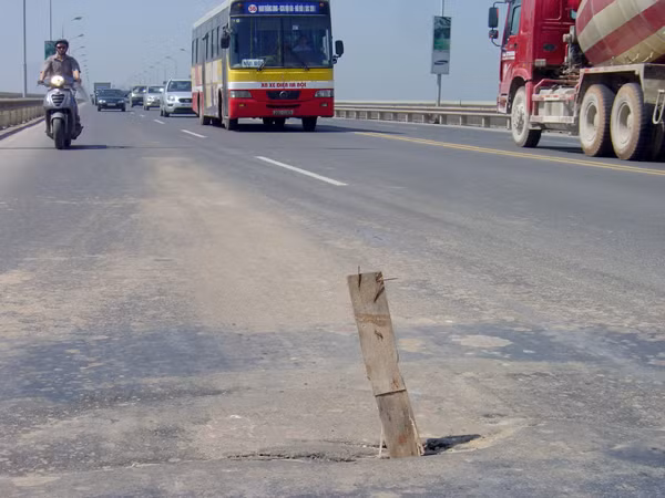 Người dân dùng thanh gỗ để cảnh báo cho các phương tiện qua lại