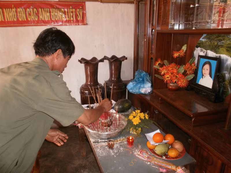 Ông Nguyễn Sỹ Diệu đang thắp hương cho con gái