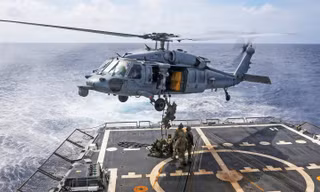 Các kỹ thuật viên xử lý vật liệu nổ lên trực thăng MH-60R Sea Hawk, thuộc Phi đội Trực thăng Tác chiến Biển 14, từ boong tàu khu trục tên lửa dẫn đường lớp Arleigh Burke USS Frank E. Petersen Jr. ngày 1/1/2026. Ảnh: US Navy.