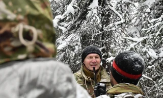 Binh sĩ thuộc Lữ đoàn Bộ binh số 2, Sư đoàn Dù số 11 ẩn nấp trong đài quan sát được làm từ cành cây trong khi chờ Lữ đoàn Bộ binh số 1 “tấn công” trong cuộc tập trận JPMRC 26-02. Ảnh: Breaking Defense.