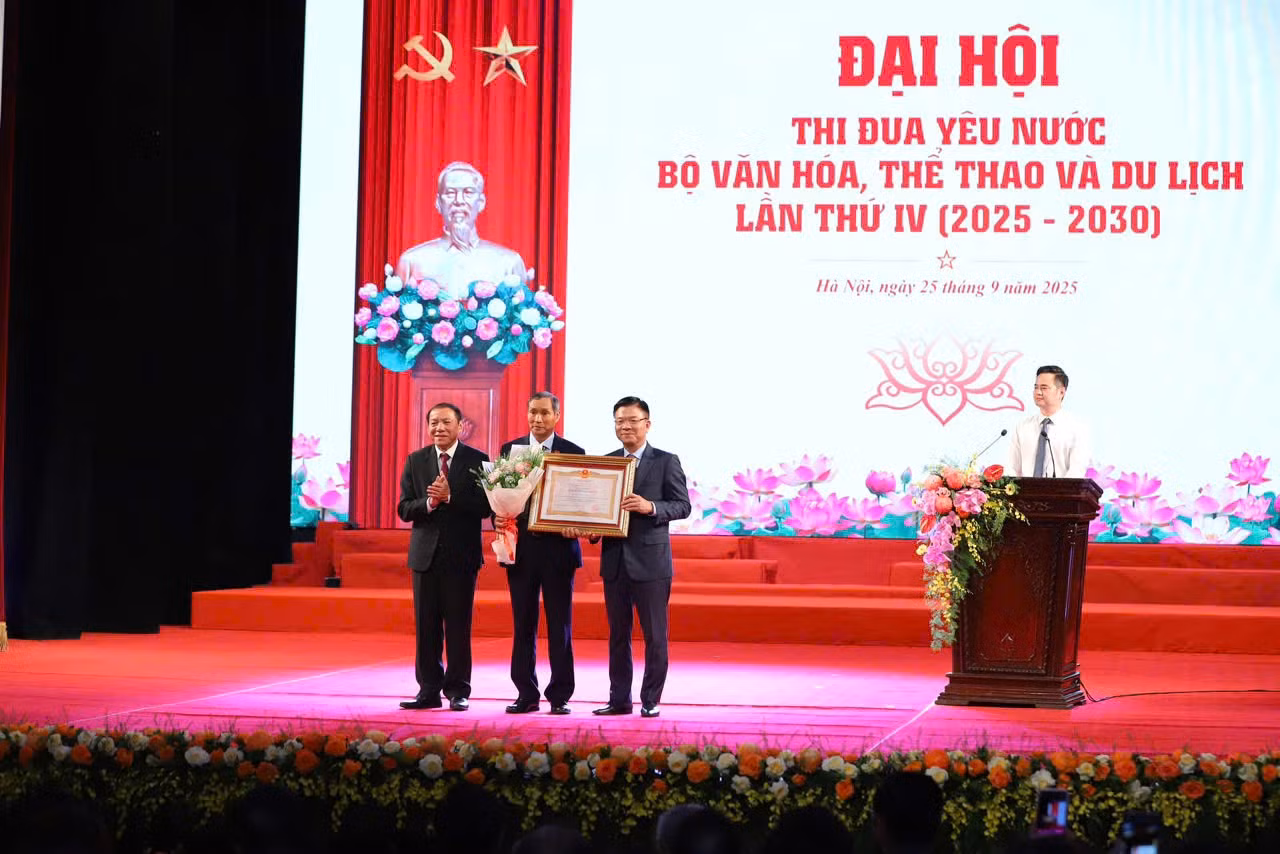 Phó Thủ tướng Lê Thành Long, Bộ trưởng Bộ VHTTDL Nguyễn Văn Hùng trao danh hiệu Anh hùng Lao động và hoa cho HLV Mai Đức Chung. Ảnh: Cổng TTĐT Bộ VHTTDL.