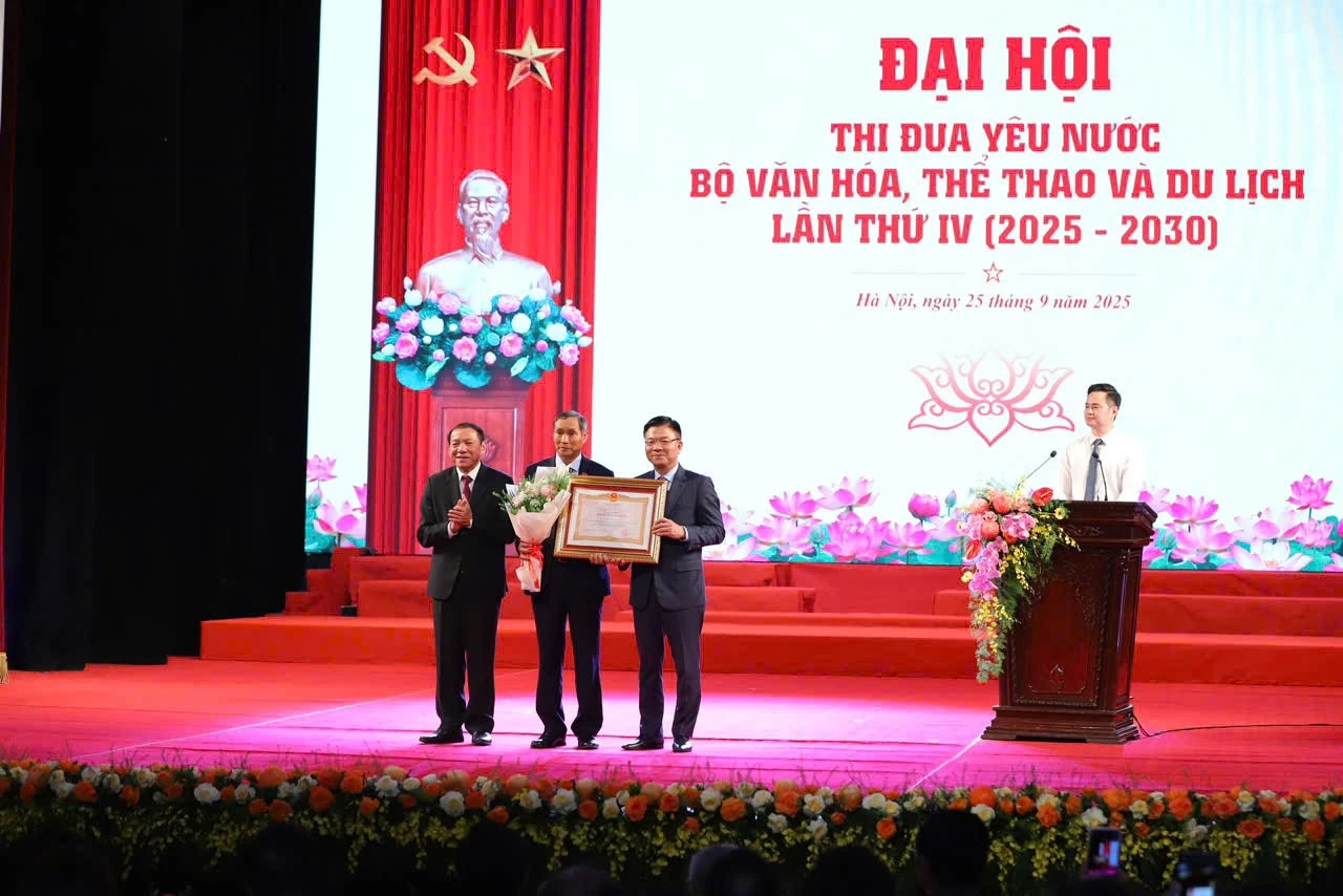 Phó Thủ tướng Lê Thành Long, Bộ trưởng Bộ VHTTDL Nguyễn Văn Hùng trao danh hiệu Anh hùng Lao động và hoa cho HLV Mai Đức Chung. Ảnh: Cổng TTĐT Bộ VHTTDL.