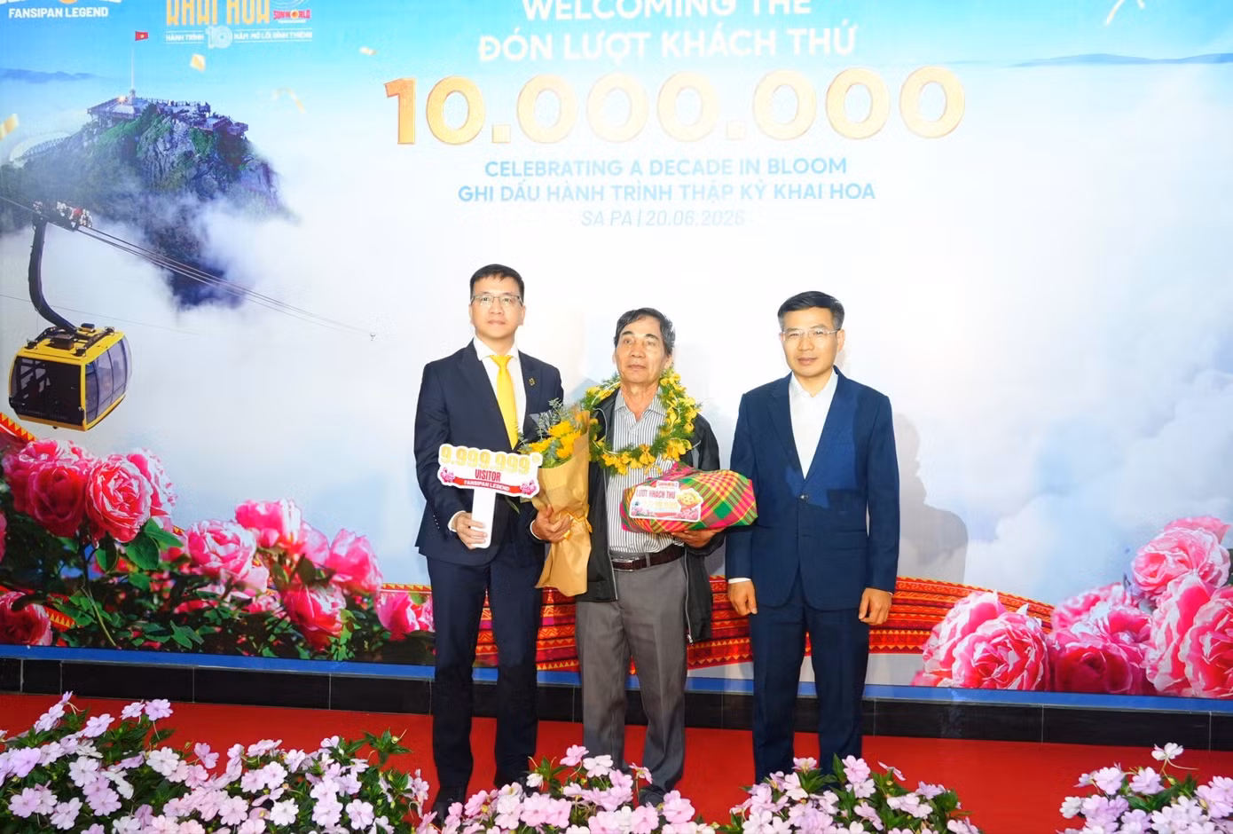 Ông Nguyễn Anh Vũ – Phó Tổng quản lý Sun World Fansipan Legend (bên trái) và ông Đỗ Văn Tân - Bí Thư Đảng ủy - Chủ tịch HĐND Xã Tả Van (bên phải) trao quà cho vị khách thứ 9.999.999.