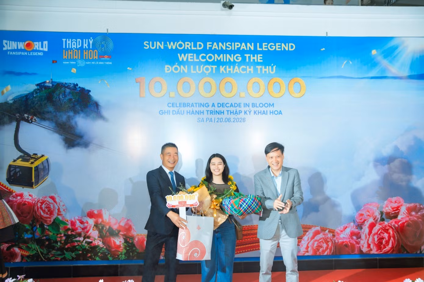 Ông Phạm Cao Vỹ - Chủ tịch Hiệp hội Du lịch tỉnh Lào Cai (bên trái) trao quà tặng cho vị khách thứ 10 triệu.