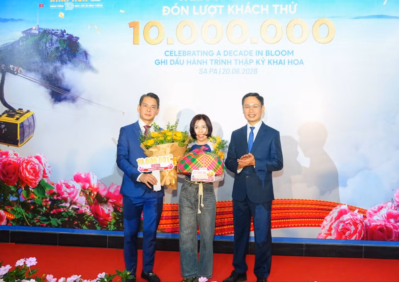 Ông Đặng Việt Dũng, Ủy viên Ban Thường vụ Đảng ủy phường, Phó Chủ tịch Thường trực UBND phường Sa Pa (bên trái) trao quà cho vị khách 10.000.001.