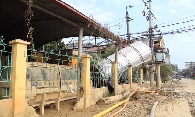 Một đoạn bờ tường, hàng rào bị sạt lở, cong vênh.