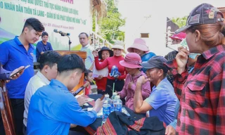 Lực lượng tình nguyện viên hỗ trợ bà con 2 thôn Tà Lang, Giàn Bí thực hiện thủ tục hành chính trực tuyến tại nhà Gươl