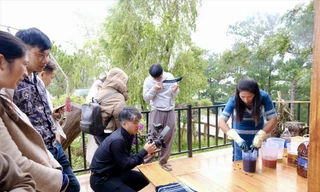 Du khách trải nghiệm nhuộm sợi cùng chị Bon Niêng K’Gút (bìa phải)