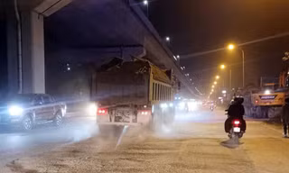 Xe chở vật liệu cuốn theo bụi mù mịt