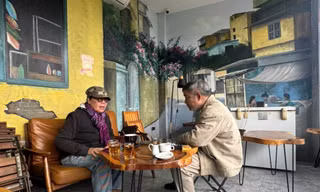 Nhà văn Y Ban (trái) tại quán cà phê ven sông Hồng