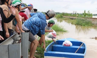 Người dân hỗ trợ nhu yếu phẩm cho bà con các khu vực bị ngập sâu, cô lập Ảnh: Giang Thanh
