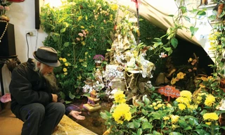 Tiến sĩ Nguyễn Thái Tự bên khu non bộ mô phỏng động Phong Nha - Kẻ Bàng dưới chân cầu thang