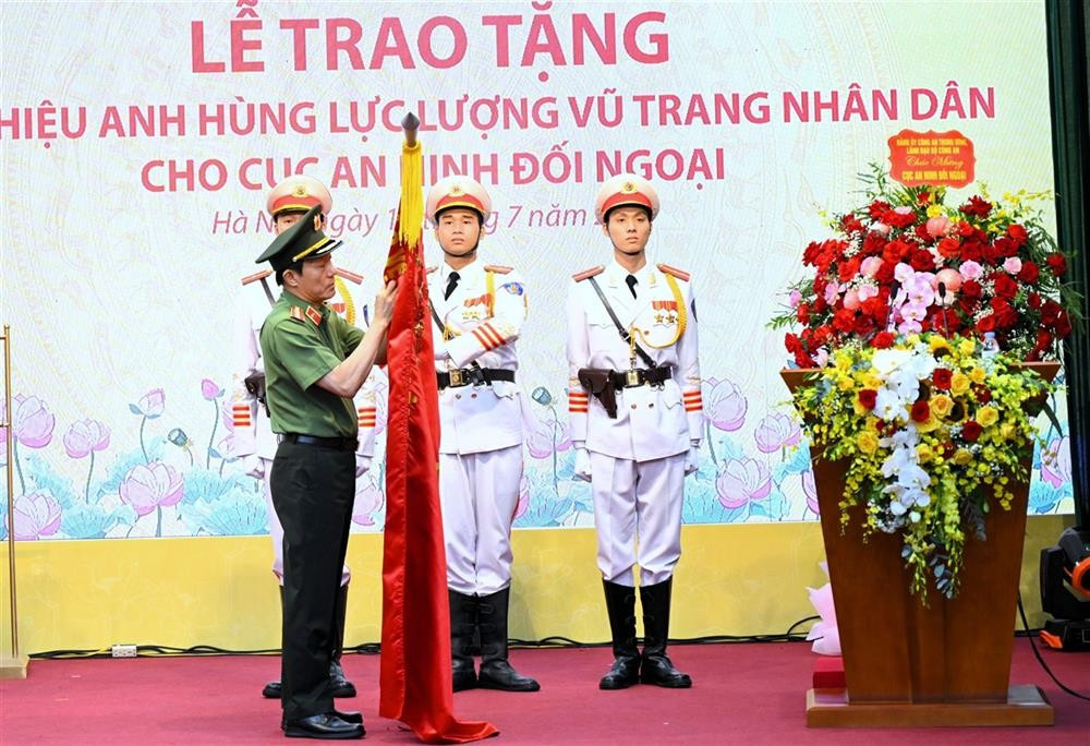 Bộ trưởng Lương Tam Quang trân trọng gắn danh hiệu Anh hùng lực lượng vũ trang nhân dân lên lá cờ truyền thống của Cục An ninh đối ngoại. 11.jpg