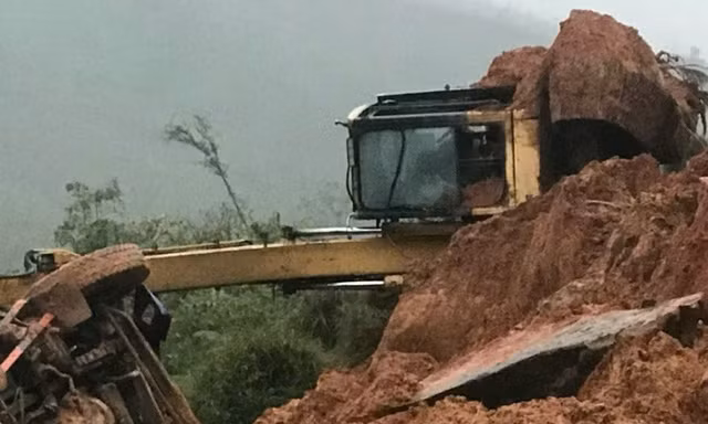 Đất, đá từ trên núi đổ tràn xuống đường, máy xúc và xe tải lật ngang