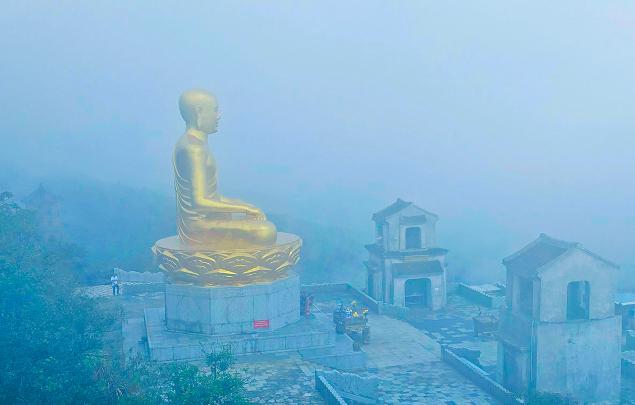 Và rồi sương mù – thứ đặc sản của Yên Tử – nhẹ nhàng phủ kín tầm mắt, như một màn che khiến ta buộc phải soi vào bên trong. Màn sương bao bọc lấy tượng Phật hoàng khiến gương mặt thiền định ấy vừa hiện rõ vừa mơ hồ, vừa gần vừa xa, như chính giáo lý vô thường mà ngài để lại. 1000022251.jpg