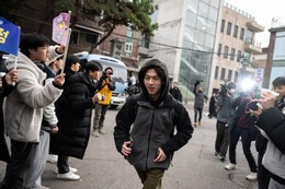 Một thí sinh đến địa điểm thi được các học sinh nhỏ tuổi hơn cổ vũ. Ảnh: Korea Times