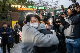 Người mẹ ôm con gái động viên trước khi con vào thi. Ảnh: Korea Times