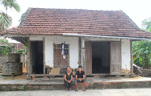 Phương và bà ngoại bên căn nhà vách đất ọp ẹp. Ảnh: Đức Hùng