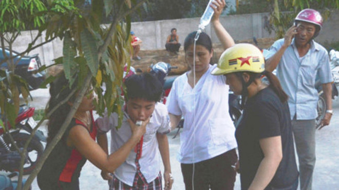 Các em học sinh vừa truyền dịch vừa cố nôn quả ngô đồng đã ăn phải (Ảnh: Gia đình và xã hội)