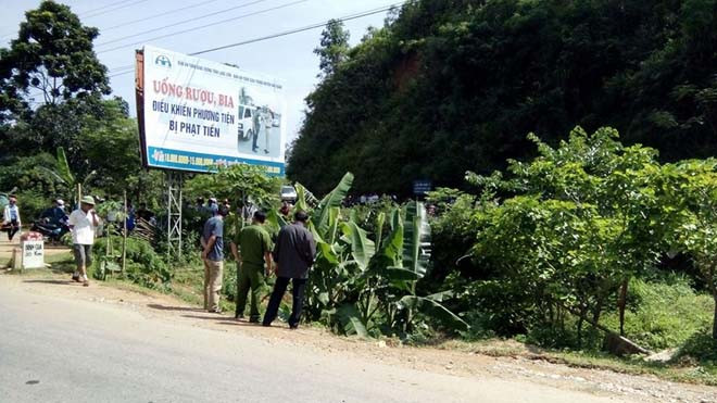 Lực lượng chức năng nỗ lực đưa thi thể nạn nhân lên trên đường quốc lộ. Ảnh: Hà Thắm