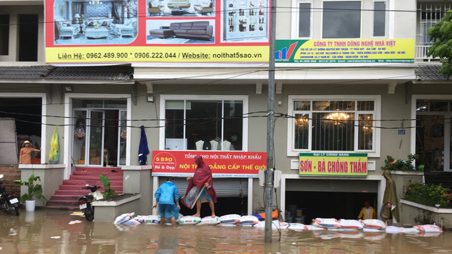 Người dân khu đô thị Geleximco - Lê Trọng Tấn đắp bao tải cát để ngăn nước vào biệt thự. Ảnh: Trường Phong
