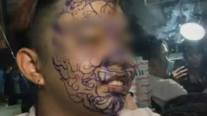 Chàng trai trong clip xăm kín mặt gây tranh cãi. Ảnh cắt từ clip.