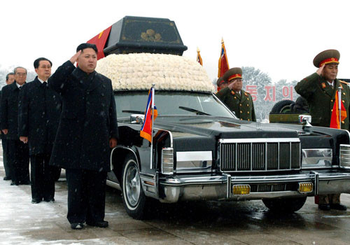 Lãnh đạo Triều Tiên Kim Jong-un (trái) đứng bên cạnh chiếc xe Lincoln Continental chở quan tài cố lãnh tụ Kim Jong-Il. Ảnh: AP.