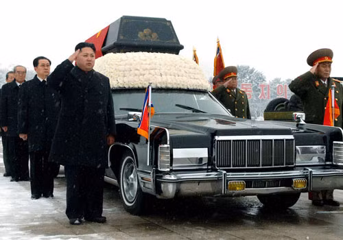 Lãnh đạo Triều Tiên Kim Jong-un (trái) đứng bên cạnh chiếc xe Lincoln Continental chở quan tài cố lãnh tụ Kim Jong-Il. Ảnh: AP.